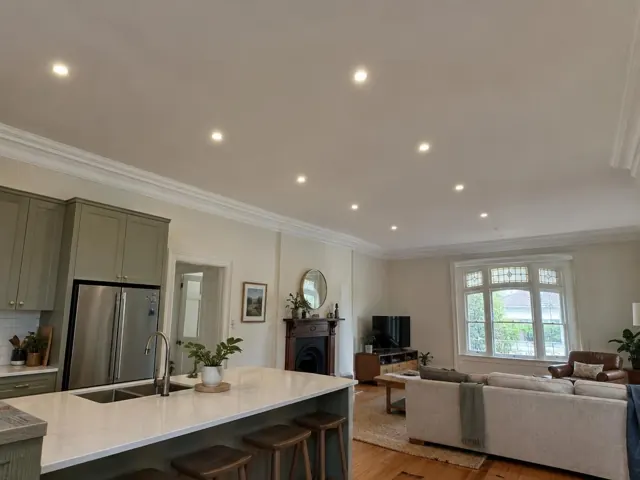 Open-plan home interior with recessed ceiling downlights above kitchen and living area in Maitland